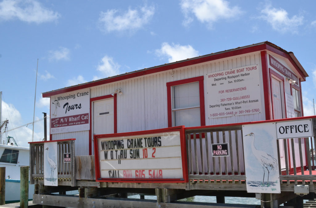 photo of M/V Wharf Cat offices in Rockport, Texas with signs about whooping crane boat tours